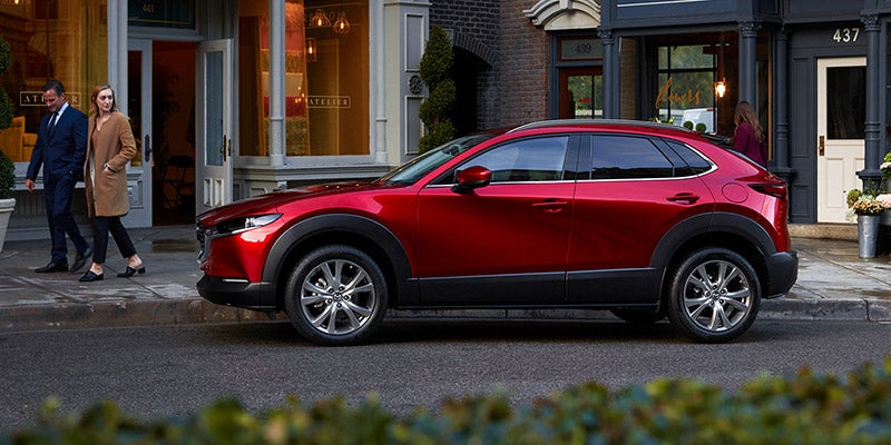 Couple walking next to a Red 2020 Mazda CX-30