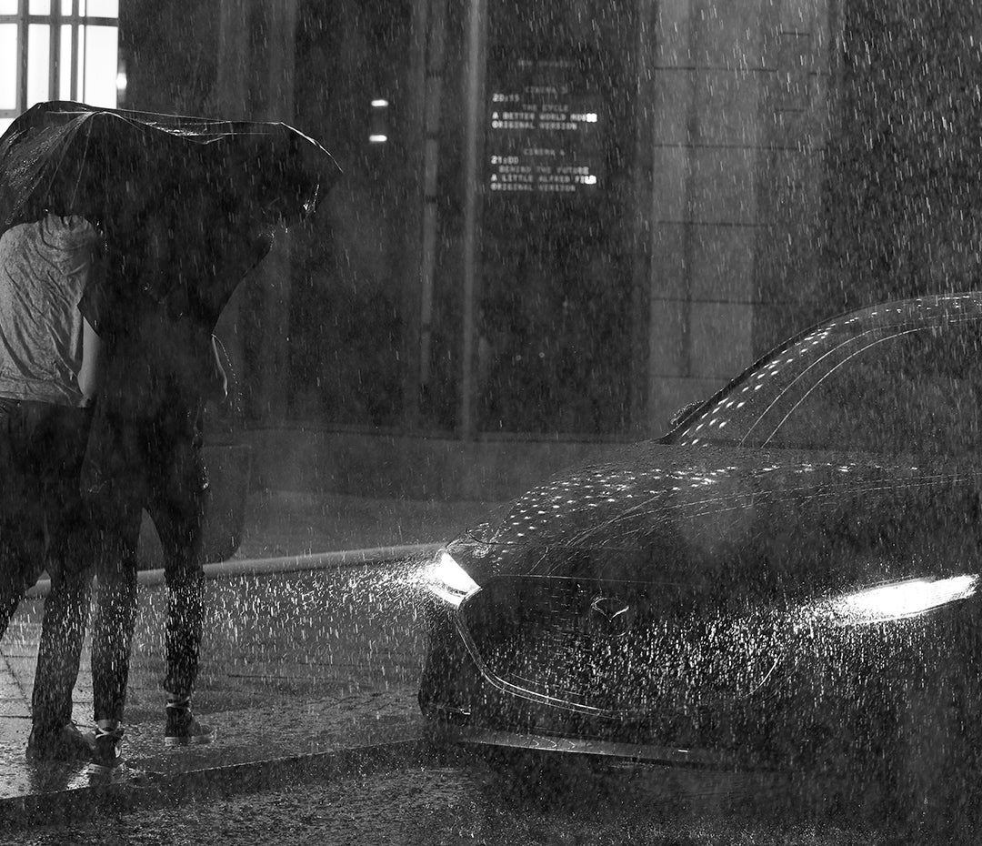 Couple walking in the rain to their 2019 Mazda3 Sedan